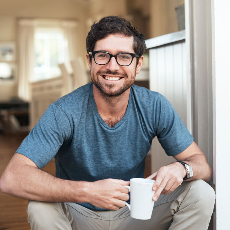adult man smiling with cup of coffee